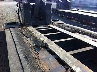 Weathered trailer floor showing surface checking and dimensional change after years without finish